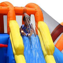 A kid is sitting at the top of a water slide